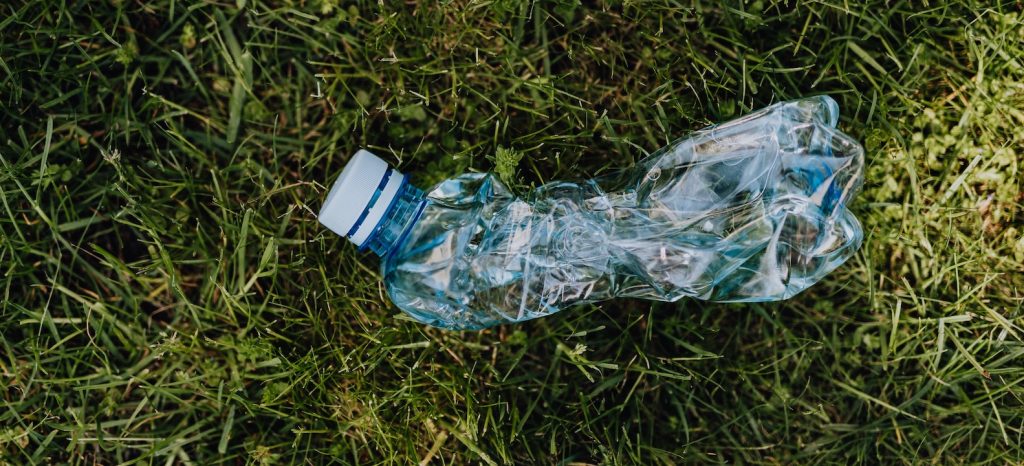 plastic flesje op het gras